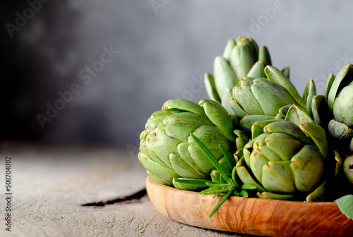 Artichoke flowers in wooden plate. Selective focus.