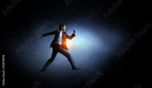 Portrait of energetic businessman running