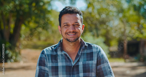 Portrait of young man in the casual shirt in the farm on the colorful sky background.