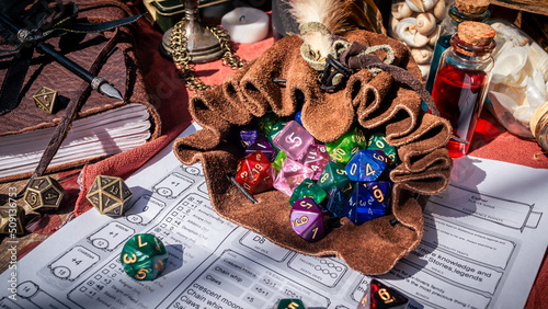 A leather dice bag filled with dice on a character sheet