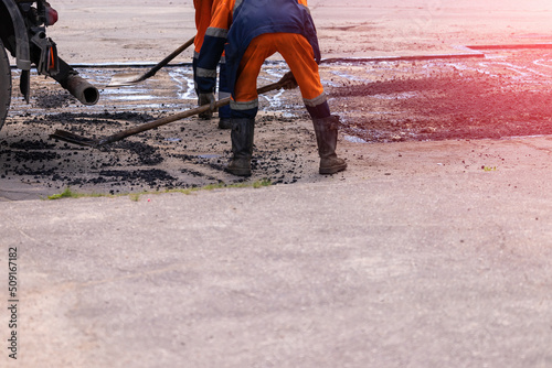 road workers repairing asphalt pavement