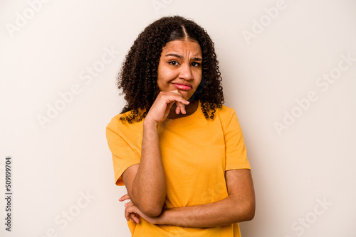 Young African American woman isolated on white background thinking and looking up, being reflective, contemplating, having a fantasy.