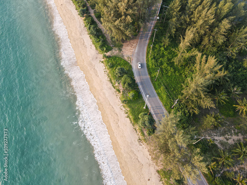 top view soft wave hit beach with tree and road