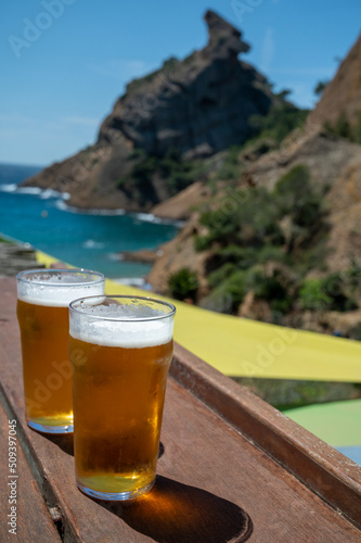 Two glasses of fresh cold lager beer served outdoor in snack bar with view on Calanque de Figuerolles in La Ciotat, Provence, France