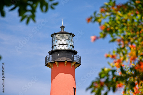 Historic red brick Jupiter lighthouse against blue skies at Jupiter Inlet, Florida