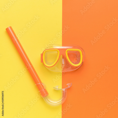 Yellow orange mask and snorkel on a yellow orange background. Minimal concept of summer recreation and scuba diving.