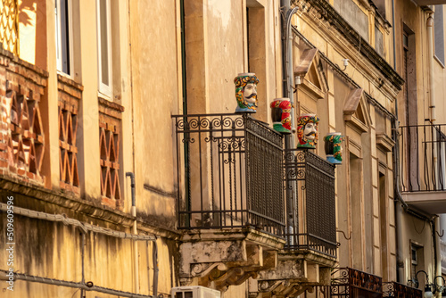 Traditional Sicilian human ceramic Moorish heads on a decorated balcony of urban house in Taormina town, island Sicily, Italy, Europe, EU. Walking in old Mediterranean street in Italy