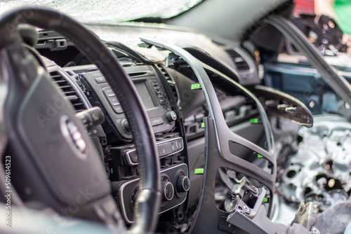 Close-up of the steering wheel of a car after an accident. The driver's airbags did not deploy. Soft focus. Broken windshield with steering wheel. Vehicle interior. Black dashboard and steering wheel.