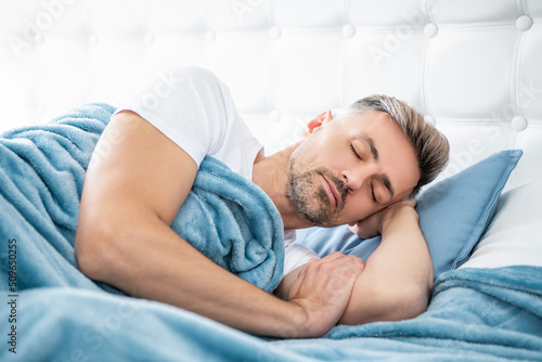 mature man having siesta in bed. early morning