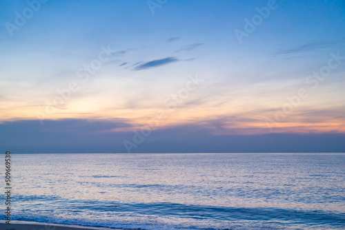Calm sea with sunset sky and sun through the clouds over. ocean and sky background. Tranquil seascape. Horizon over the water. Sunset sky over sea in the evening with colorful clouds orange sunlight