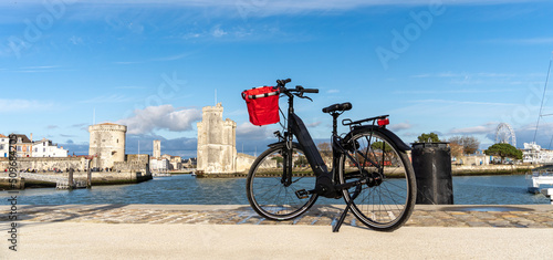 La Rochelle old harbor. Rear view of a bicycle looking at city view while standing on observation point.