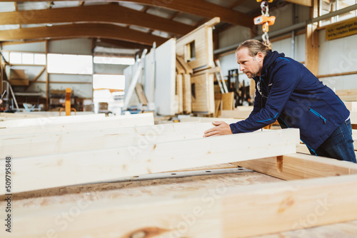 Carpenter working on a wooden wall. Prefabricated house