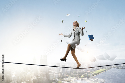 Young pretty businesswoman juggling with business items