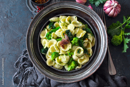 Italian pasta Orecchiette with brocoli and anchovies on dark table. Top view with copy space. Healthy food.