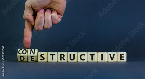 Destructive or constructive symbol. Businessman turns cubes and changes the concept word Destructive to Constructive. Beautiful grey background. Business constructive destructive concept. Copy space.