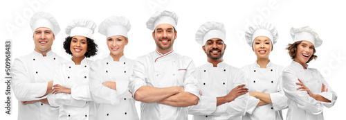 cooking, culinary and profession concept - international team of smiling chefs with crossed arms