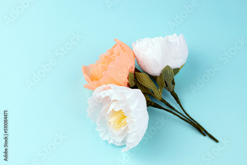Hand made crepe paper peonies bouquet on blue background. Paper peony DIY concept
