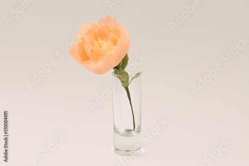 Single hand made crepe paper peony in a vase on white background. Paper peony DIY concept