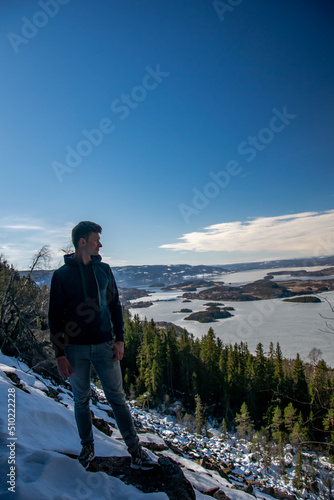 Mężczyzna na tle ośnieżonej panoramy norweskie fiordy