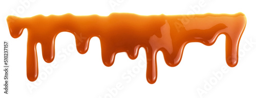 Dripping caramel drops of sweet sauce isolated on white background. Melted caramel sauce