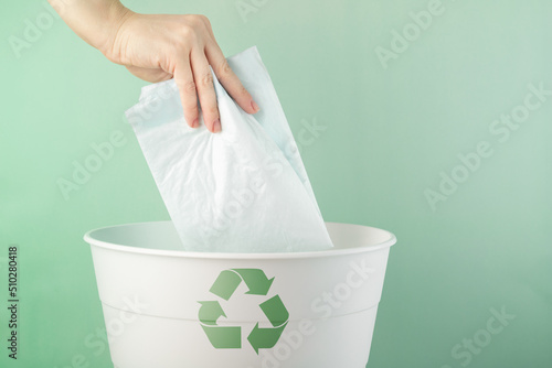 recycling, environmental protection, the hand throws the pet diaper into the bin, waste sorting