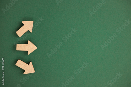 Wooden arrows point on green background. Space for your text