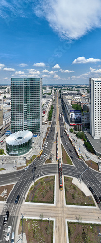 Centrum Warszawy, widok na wieżowce i biurowce, zbliżenie z lotu ptaka z drona, słońce, wiosna, niebieskie niebo, pionowa panorama 