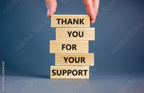 Thank you for support symbol. Concept words Thank you for your support on wooden blocks on a beautiful grey table grey background. Businessman hand. Business and thank you for support concept.