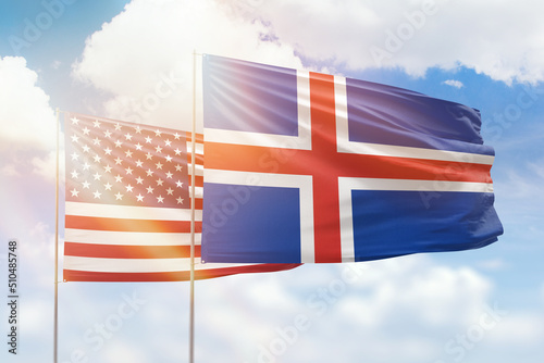 Sunny blue sky and flags of iceland and usa