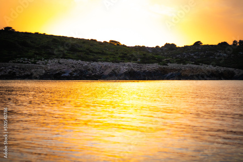Zachód słońca oblaski na wodzie morze skały morskie wyspy Minorka Baleary Hiszpania