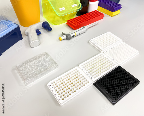 Different types of multiwell plates on the laboratory bench. Such plates are used for biological in vitro drug screening, biochemical assays, cytotoxicity evaluation, and enzyme activity assessment.