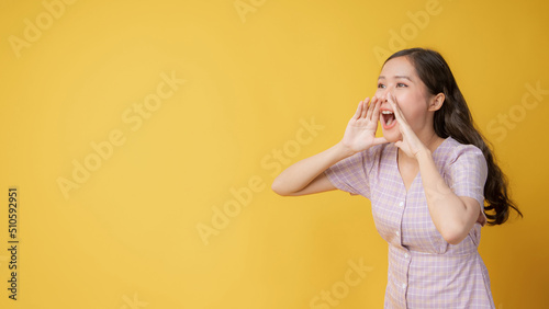 Woman teen standing big shout out with hands next mouth giving excited positive, present and call on orange background