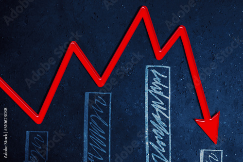 Declining red arrow and graph on blackboard