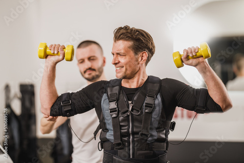 Man Doing EMS Workout With Coach In The Gym