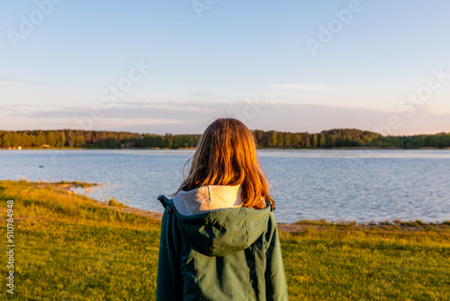 kobieta stojąca na brzegu jeziora