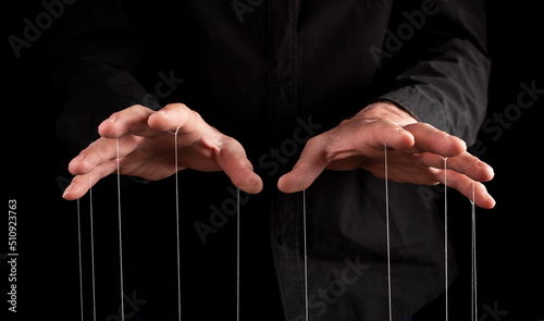 Man hands with strings at fingers. Manipulator controlling, exploiting person, showing power in relationship, at work. Dictatorship. High quality photo