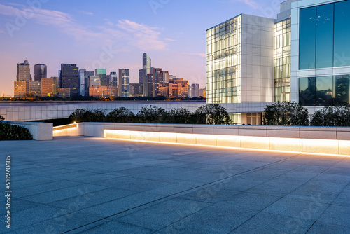 Empty square floor and city skyline with modern commercial buildings in Hangzhou at sunrise, China.