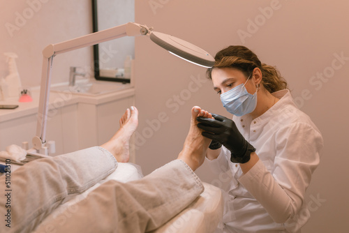 Chiropodist examining the female feet. Healthcare. Woman body care. Spa treatment.