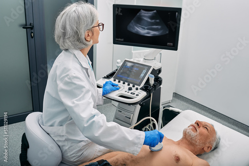 Heart ultrasound exam for senior man with ultrasound specialist while medical exam at hospital