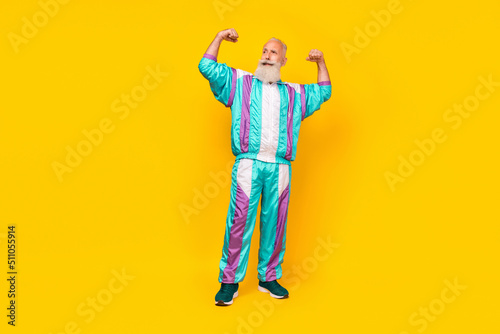 Full size photo of confident strong healthy granddad arms flexing biceps look empty space isolated on yellow color background