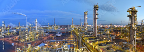 refinery - chemical factory at night with buildings, pipelines and lighting - industrial plant