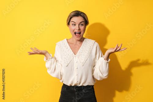 Young woman making silly face against yellow background