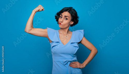 Women's rights. Feminism. Equality of gender. Powerful serious strong conceptual woman feminist shows her biceps and fist. International womens day