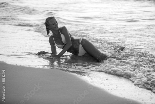 Beautiful, sexy, woman enjoying the sea waves on the beach.