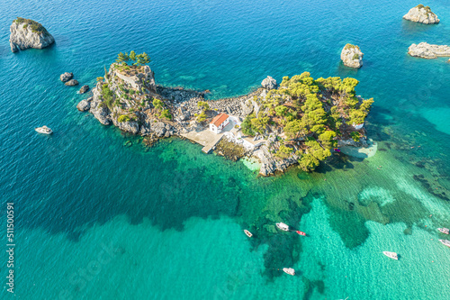 The island of Panagia with church located right in front of the port of Parga among in blue, turquoise sea water. Aerial, top, drone view. Greece