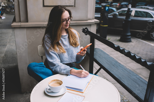 Young millennial female using social network application on mobile phone for communication. Caucasian hipster girl holding smartphone in silicone case. Teenager browsing online with internet data