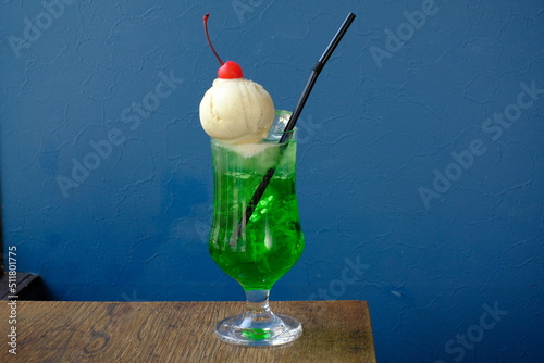 glass of melon soda with ice cream and cherry