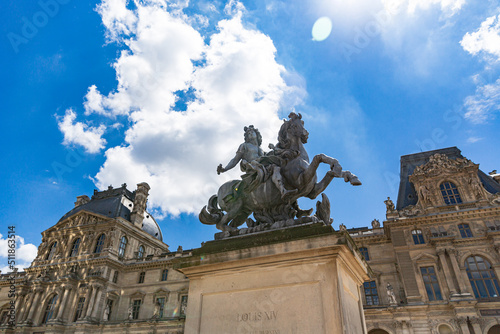 Sculpture of Louis the XIV at the Louvre museum against a beautiful sky