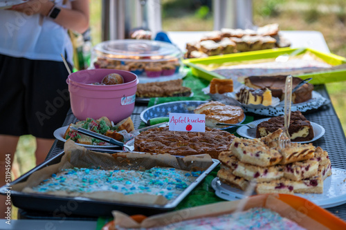 Von Eltern veranstalteter Kuchenbasar mit dem Wort Apfelkuchen in deutscher Sprache