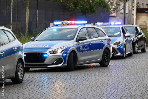 Samochód polskiej policji drogowej na sygnałach w mieście alarmowo. 